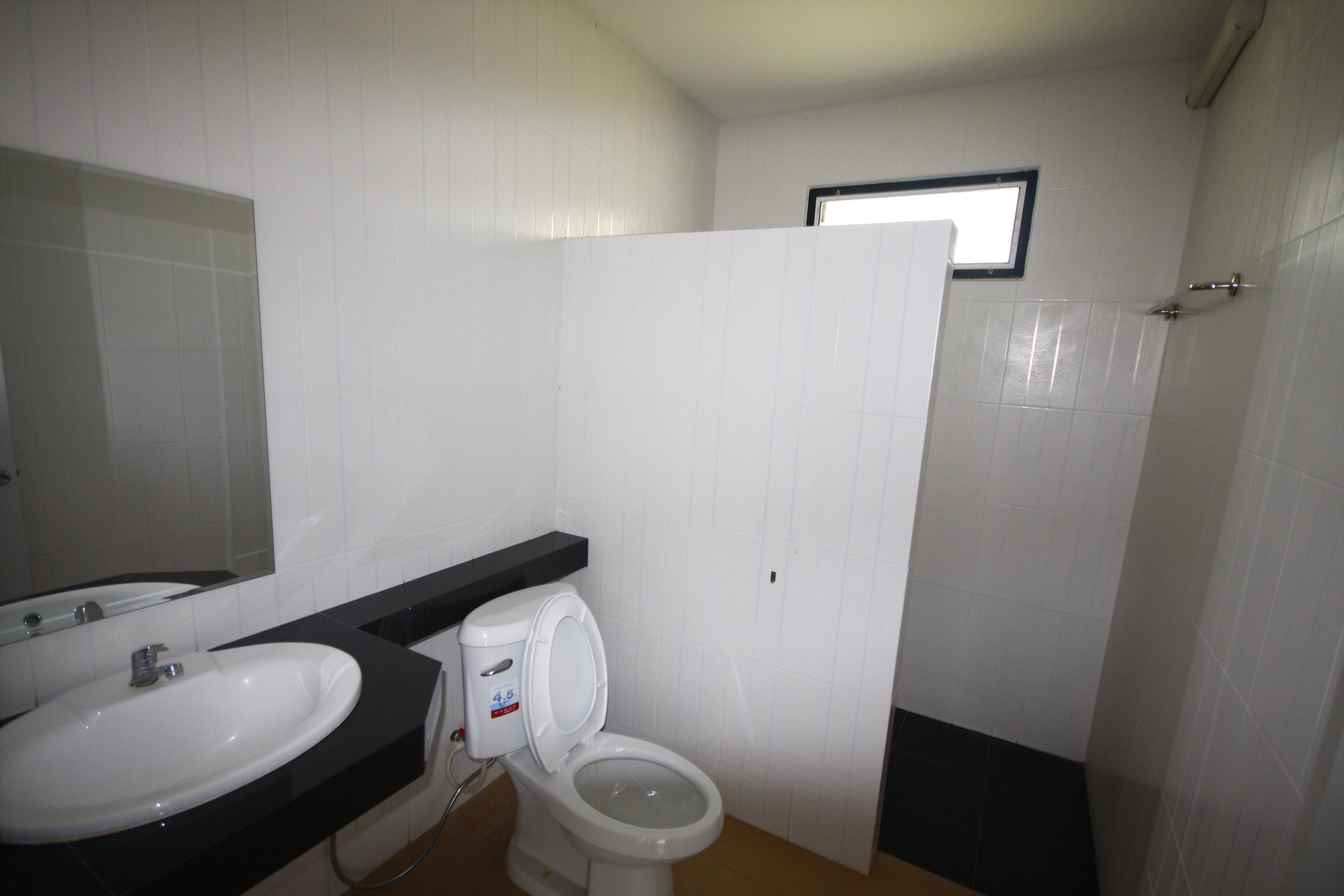 A bathroom with a white sink, a toilet, and a mirror.