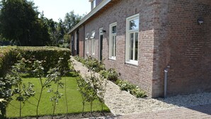 A brick building with a well-maintained lawn and a hedge. - Cozy and Komfortale holiday property, former farm (Oostkapelle)