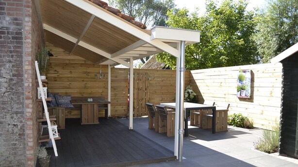 A covered patio area with wooden furniture and a brick wall. - Cozy and Komfortale holiday property, former farm (Oostkapelle)