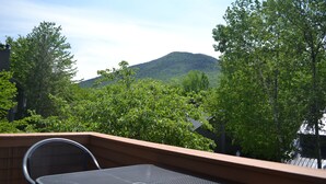 A balcony with a table and chairs, overlooking a mountain and dense greenery. - Wilderness Mountain Resort, Amazing Views In White Mountains On Kancamagus Hwy (Lincoln)