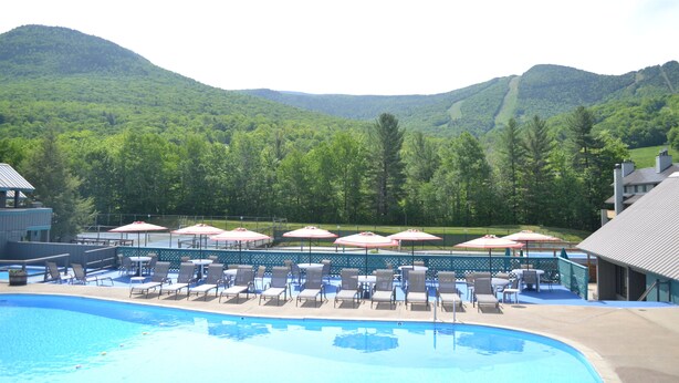 A pool area with lounge chairs and umbrellas, surrounded by a mountain backdrop. - Wilderness Mountain Resort, Amazing Views In White Mountains On Kancamagus Hwy (Lincoln)