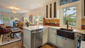 A spacious kitchen with white cabinets, a built-in dishwasher, and a large window providing natural light. - Pristine, art-filled Home 2 blocks to Historic Santa Fe Plaza. Read the reviews! (Santa Fe)
