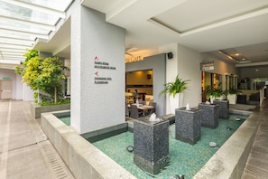 Relax in the central area surrounded by seating and a staircase, with access to a games room, multipurpose room, swimming pool, and playground.