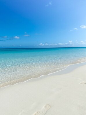 A beach with clear turquoise water and white sand.
