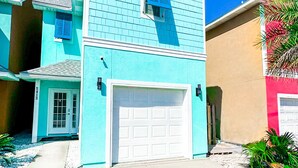 A two-story house with a white garage door and a blue exterior. - 5 bedroom Home, 5 bathrooms, Private Heated Pool+Steps to uncrowded beach+Views (Panama City)