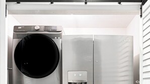 A compact, stainless steel laundry room with a built-in washer and dryer, a water dispenser, and a small storage cabinet. - 5 bedroom Home, 5 bathrooms, Private Heated Pool+Steps to uncrowded beach+Views (Panama City)