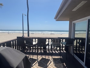 Un espacio de estar techado al aire libre con vistas a la playa y al océano.