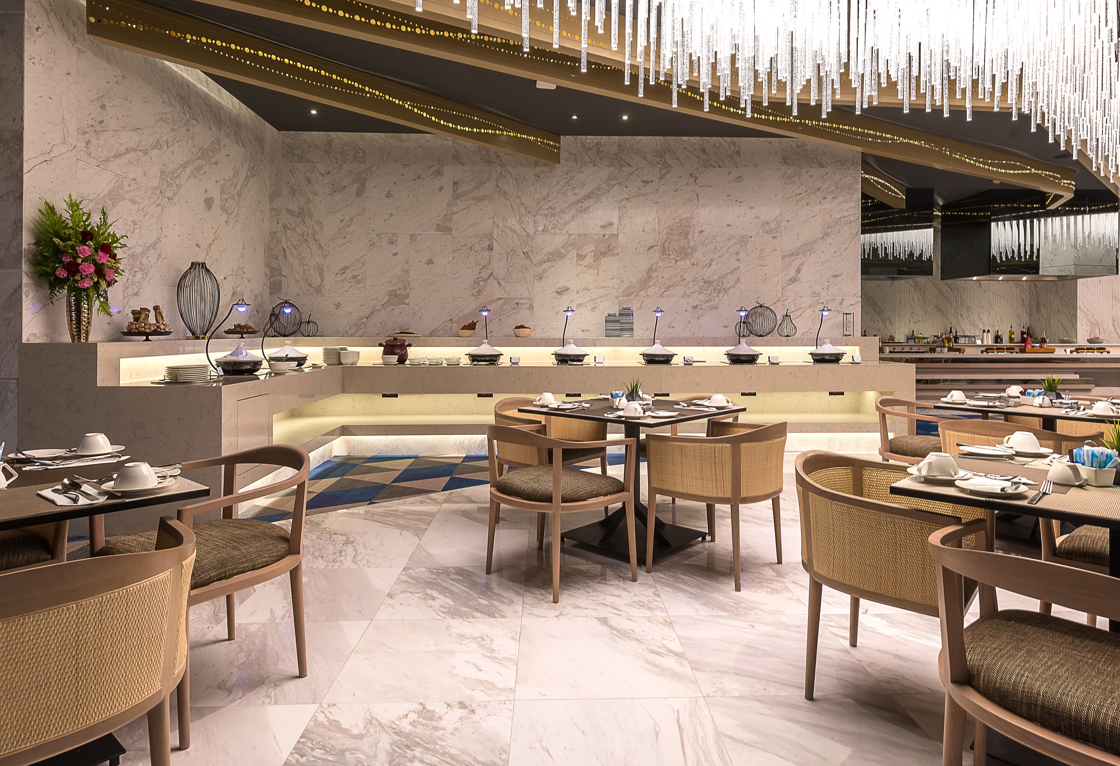 A modern restaurant with marble walls, wooden furniture, and a central bar area.