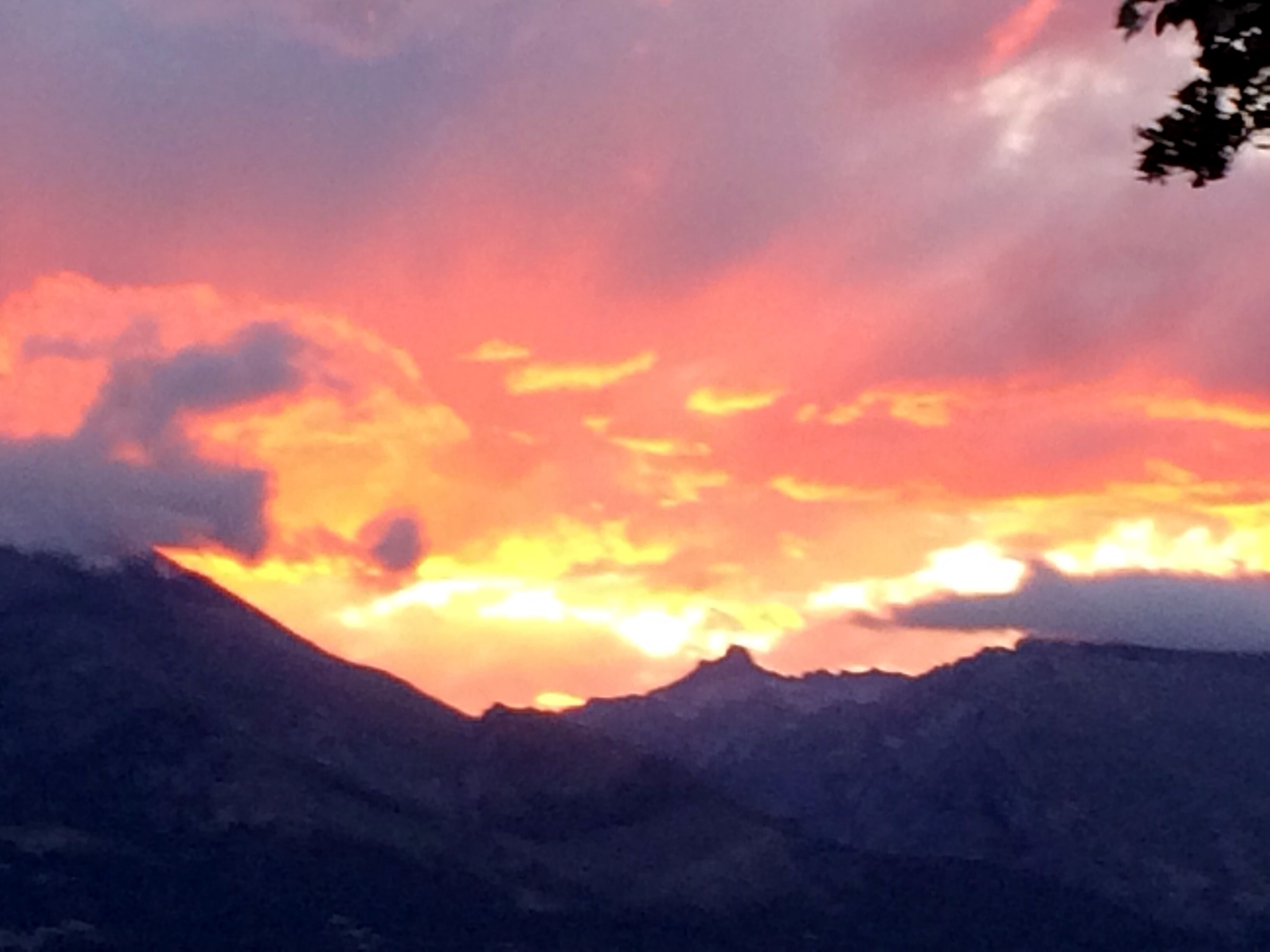 A mountain range silhouette against a sunset sky.