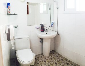 A small bathroom with a toilet, sink, and shower. - Hanok Raon (Gyeongju)
