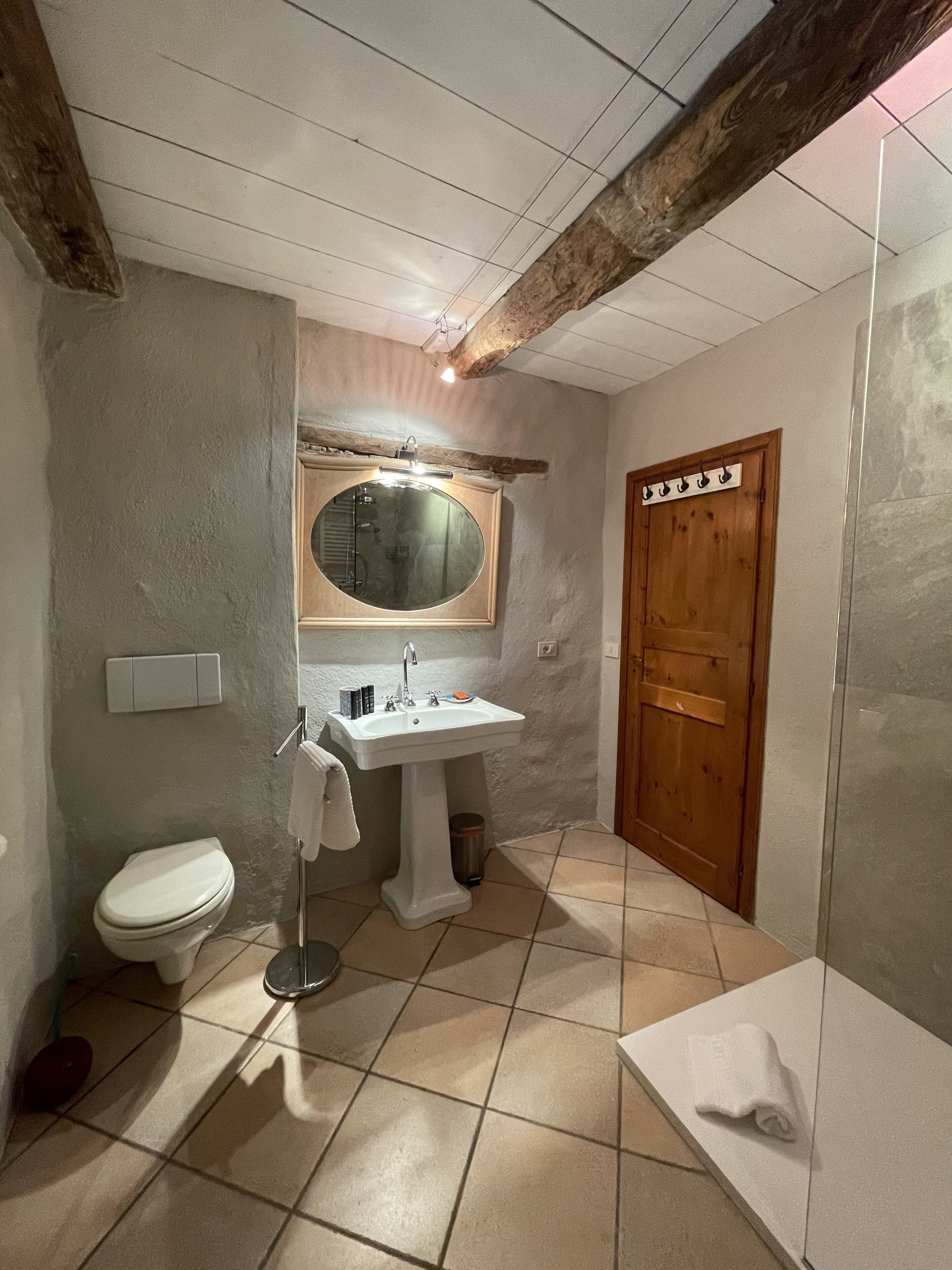 Un baño con inodoro, lavamanos y espejo.