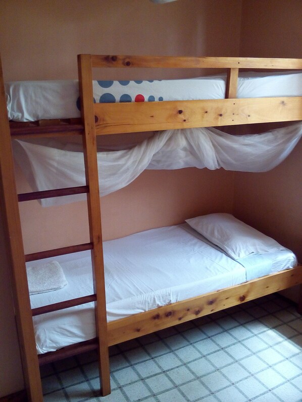 A bunk bed with white bedding and a towel on the lower bunk.