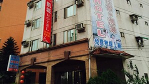 Un hotel con varios letreros, incluyendo uno del hotel y otro de servicios de masaje.