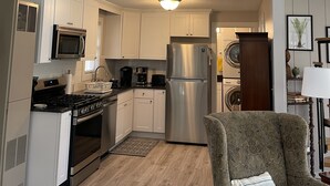 Une cuisine moderne avec des meubles blancs, des appareils en acier inoxydable et une décoration sur le thème de la voile.