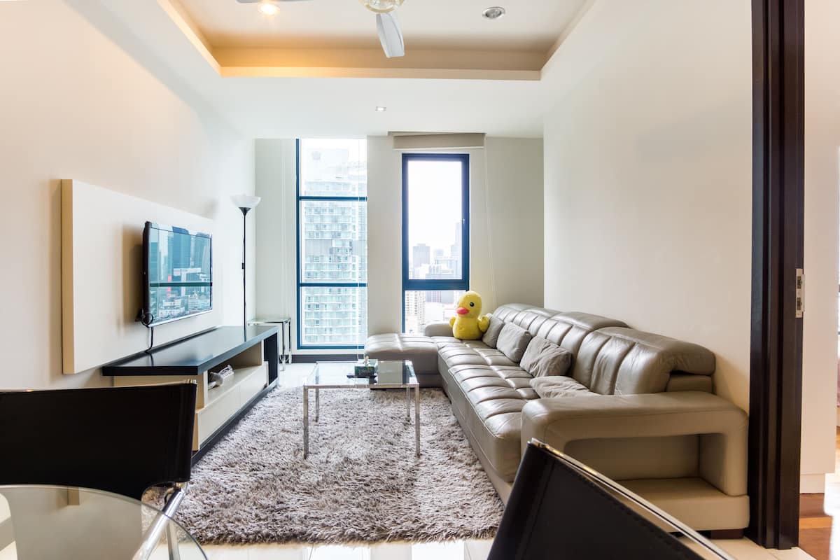 Un salon moderne avec un canapé, une table basse et un téléviseur.