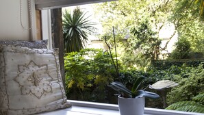 Ein Fensterplatz mit einem Zierkissen und einem Topfpflanzen.