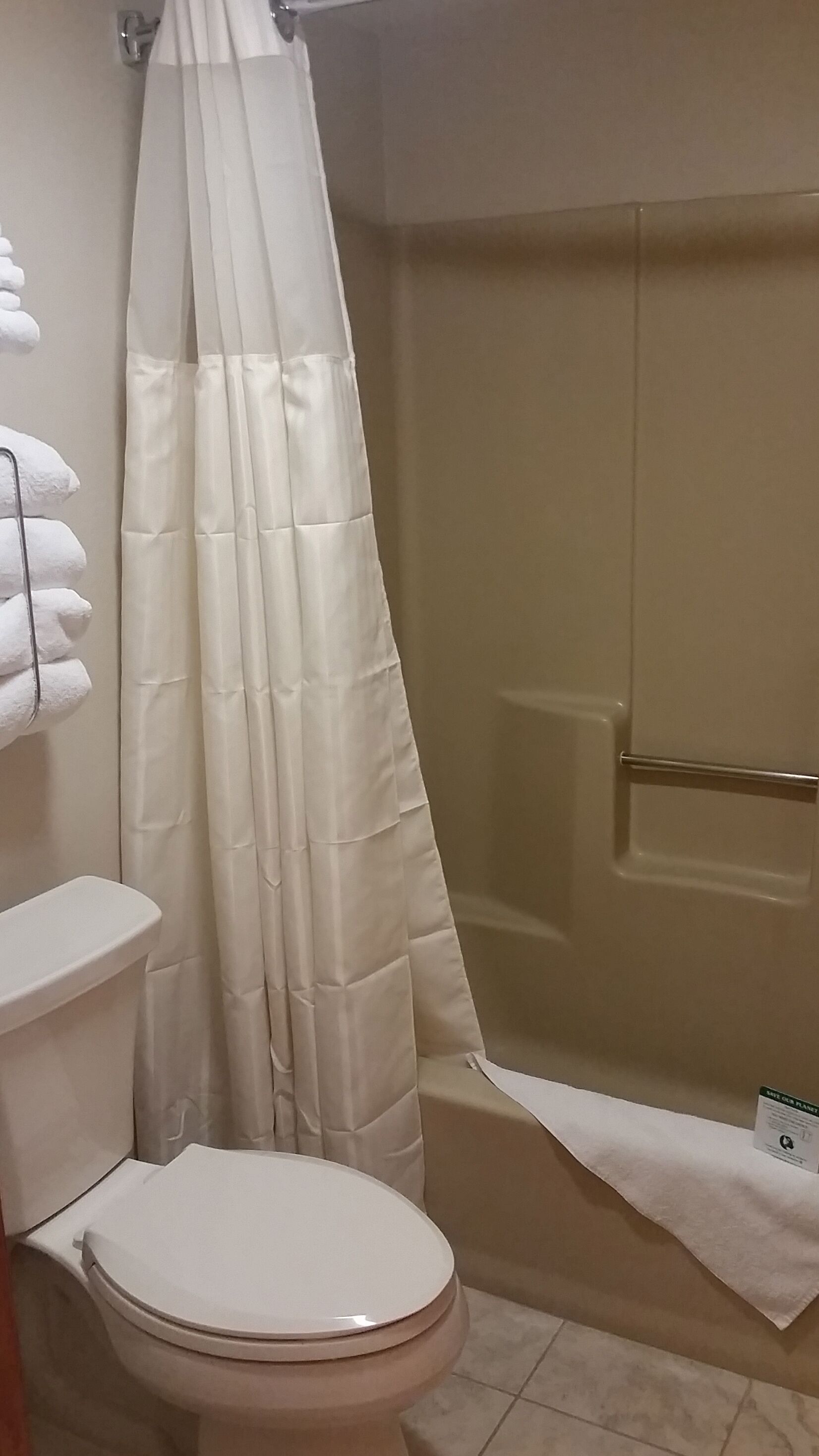 Une salle de bain comprenant des toilettes, un espace douche et une baignoire.