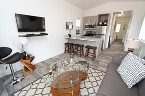Uma sala de estar moderna com um sofá, uma mesa de centro e uma televisão.