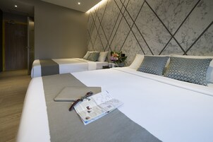 Una habitación de hotel moderna con una cama grande, una puerta de madera y una pared con diseño de mármol.