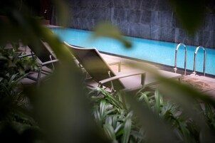 A pool area with lounge chairs and a clear view of the pool.