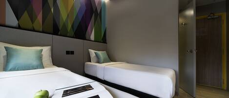 A modern hotel room with a large bed, a smaller bed, and a colorful geometric wall art.