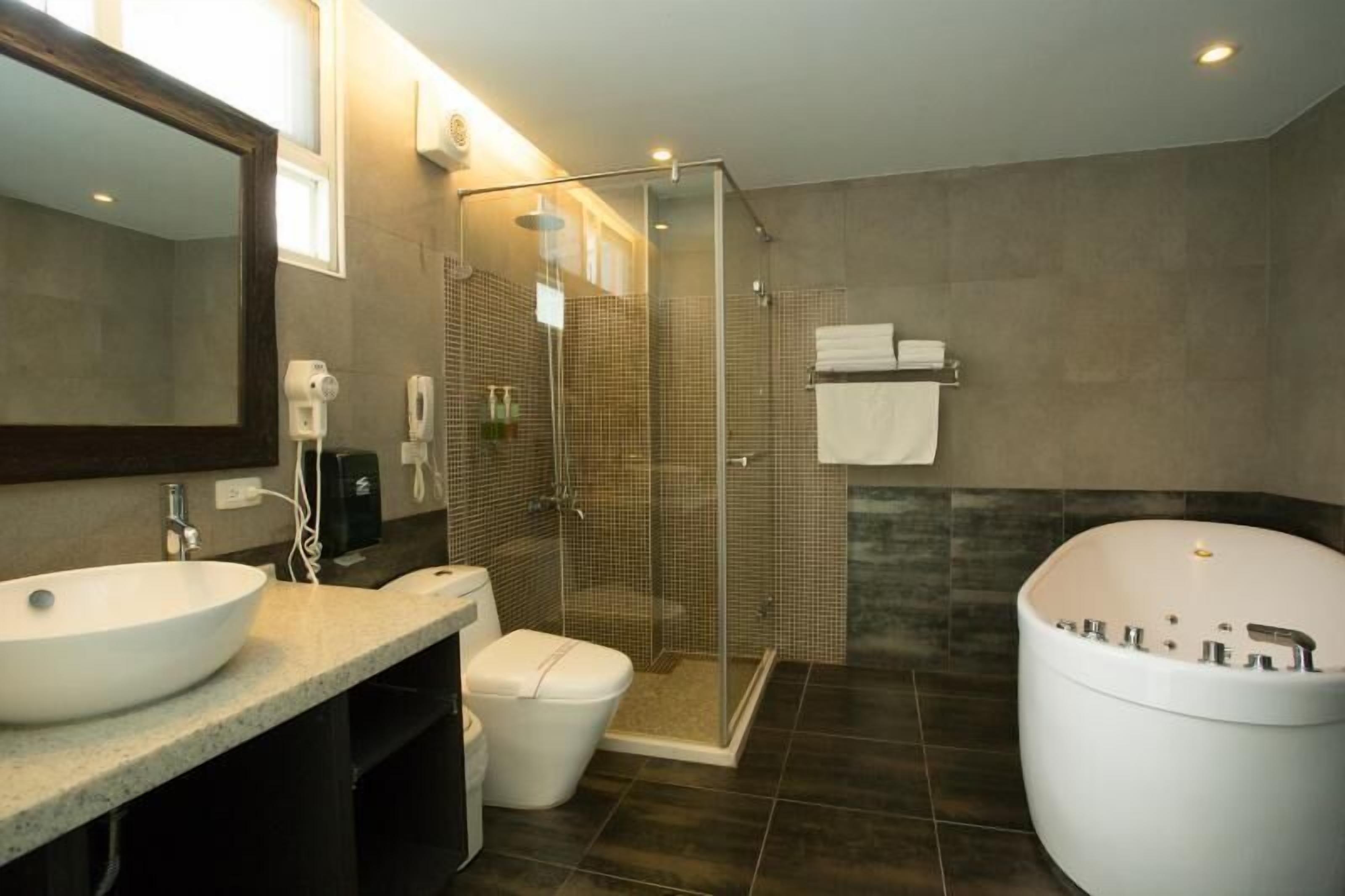 Un baño moderno con un lavamanos grande, inodoro, ducha y bañera.