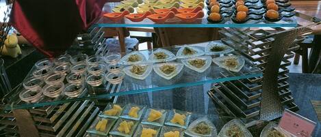 A food display with various dishes in glass containers.