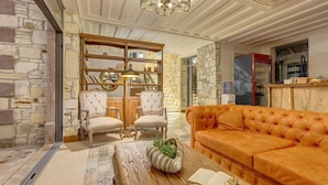 A cozy living room with a wooden coffee table, a plush orange sofa, and a bookshelf.