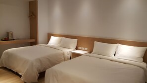 A hotel room with two beds, a bedside table, a wall-mounted heater, and a small shelf with a red object. - Ze Hu B&B (Yuchi)