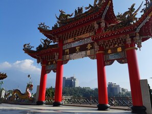 A traditional red Chinese gate with intricate designs and characters, set against a clear sky. - Ze Hu B&B (Yuchi)