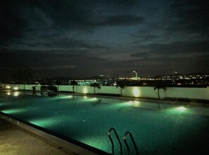 A swimming pool at night with city lights in the background. - Cozy Crib at 7 Tree Seven Residence (Cheras)