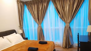 A hotel room with a bed, curtains, a desk, and a lamp. - Cozy Crib at 7 Tree Seven Residence (Cheras)