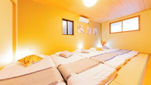 Une chambre d’hôtel avec un plafond en bois, deux fenêtres et un lit doté de plusieurs oreillers et d’une couverture.
