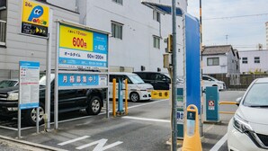 Un espace de stationnement avec un panneau indiquant un tarif de 600 yens pour une durée de stationnement de 24 heures.