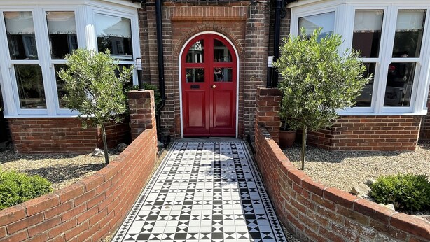 A house with a red door, white windows, and a tiled walkway. - Holway House (Sheringham)