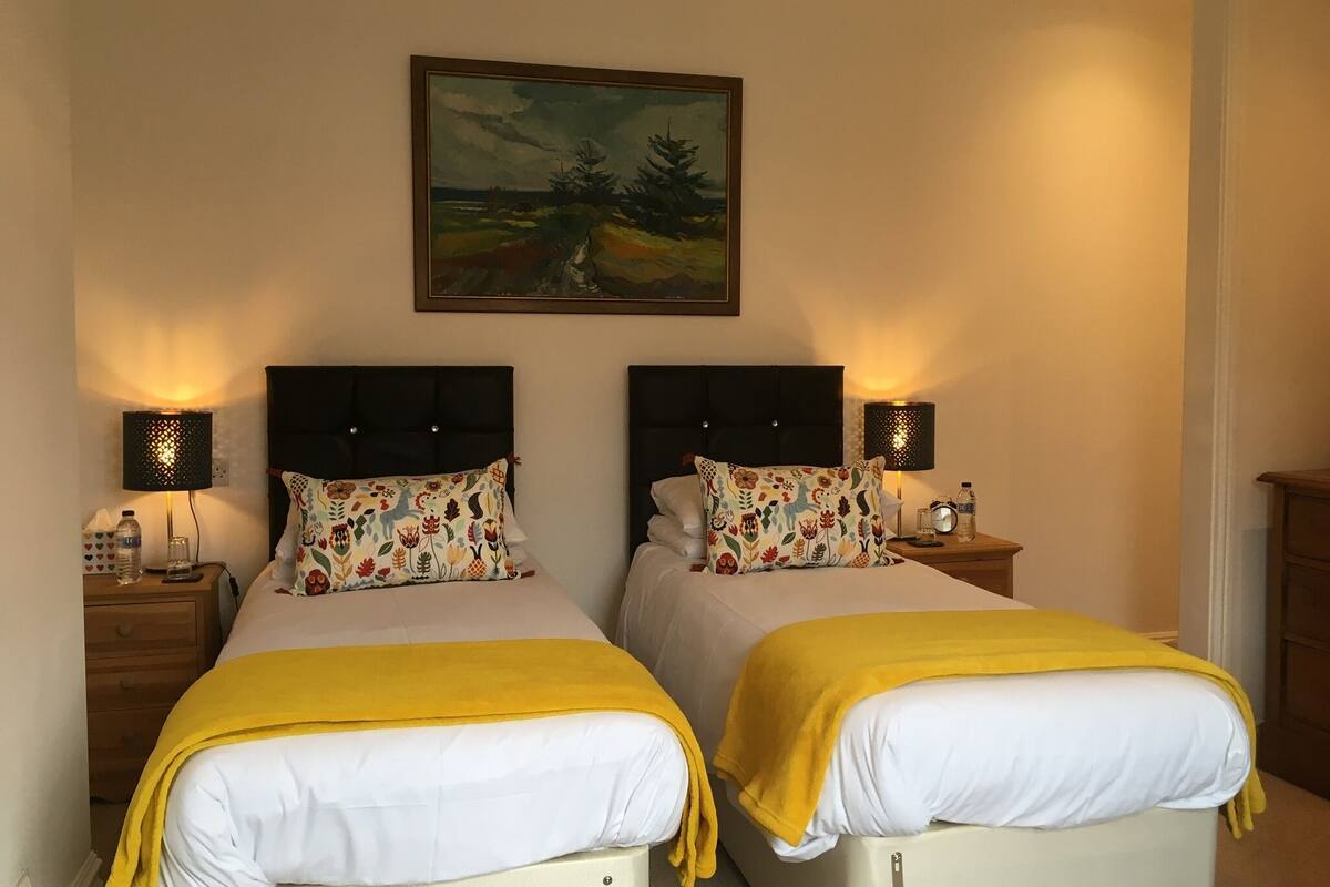 A double bed room with two nightstands, each with a lamp and a bottle of water.