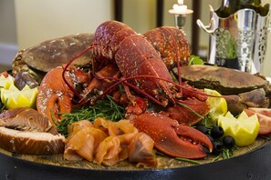 Una bandeja de mariscos con langosta, salmón y judías verdes.