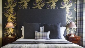 A bedroom with a large bed, two nightstands, and a dark headboard. - Glenegedale House (Islay Island)