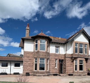 A two-story house with a stone facade, multiple windows, and a chimney. - St Olaf Golf Hotel (Peterhead)