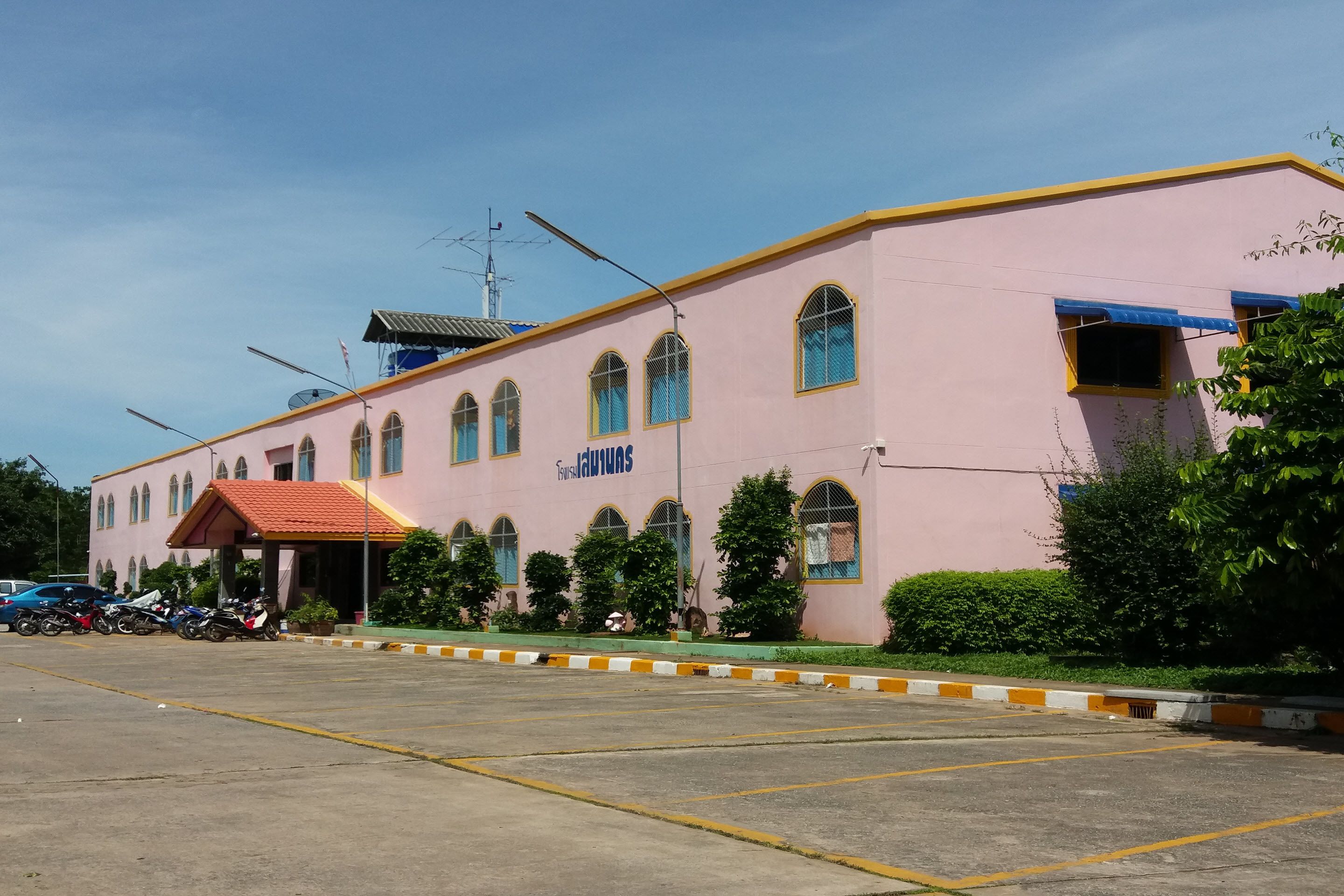 A pink building with arched windows and a red roof, labeled "TAYSAI".
