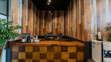 Un bar de café con paneles de madera, máquinas de café y un dispensador de agua.