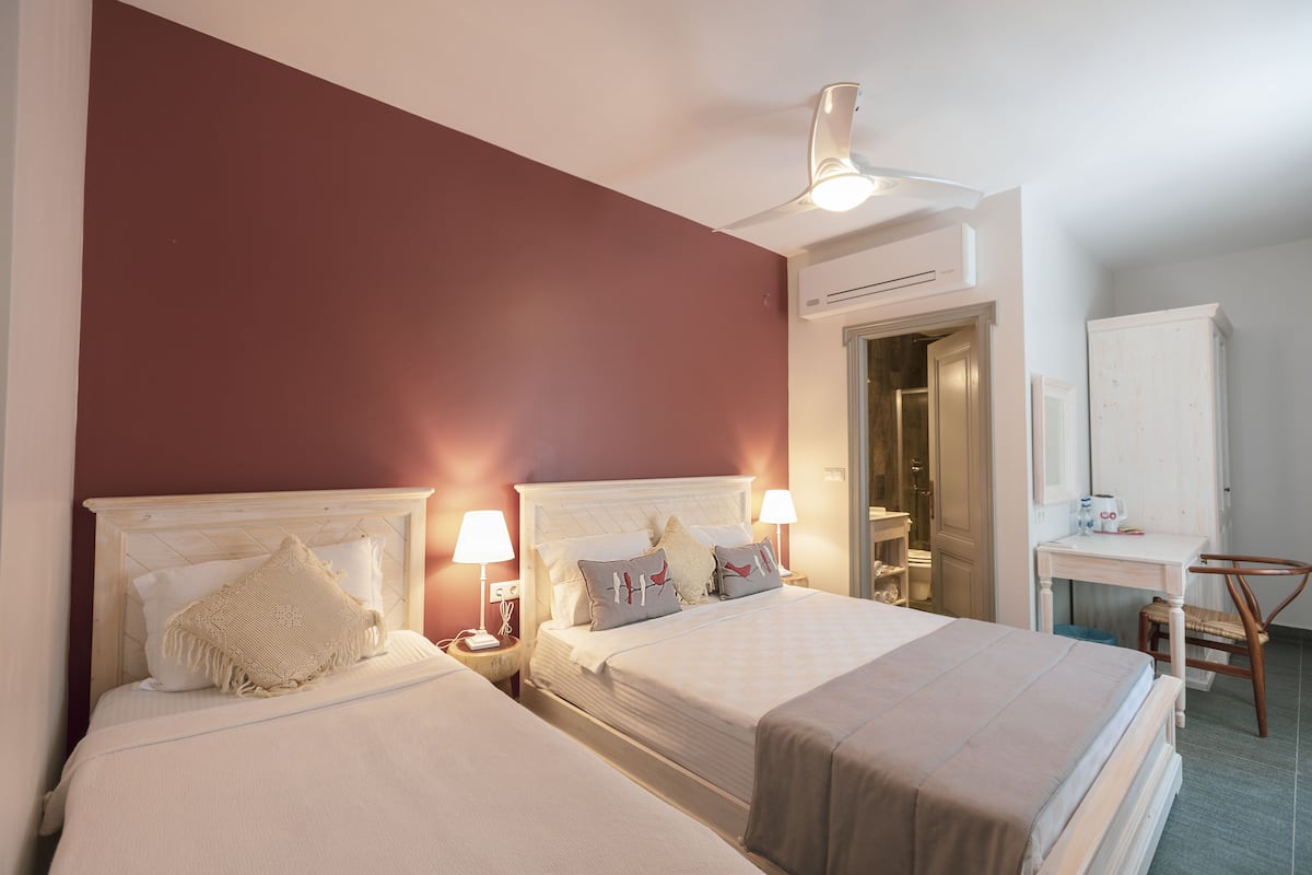 A hotel room with two beds, a desk, and a chair.