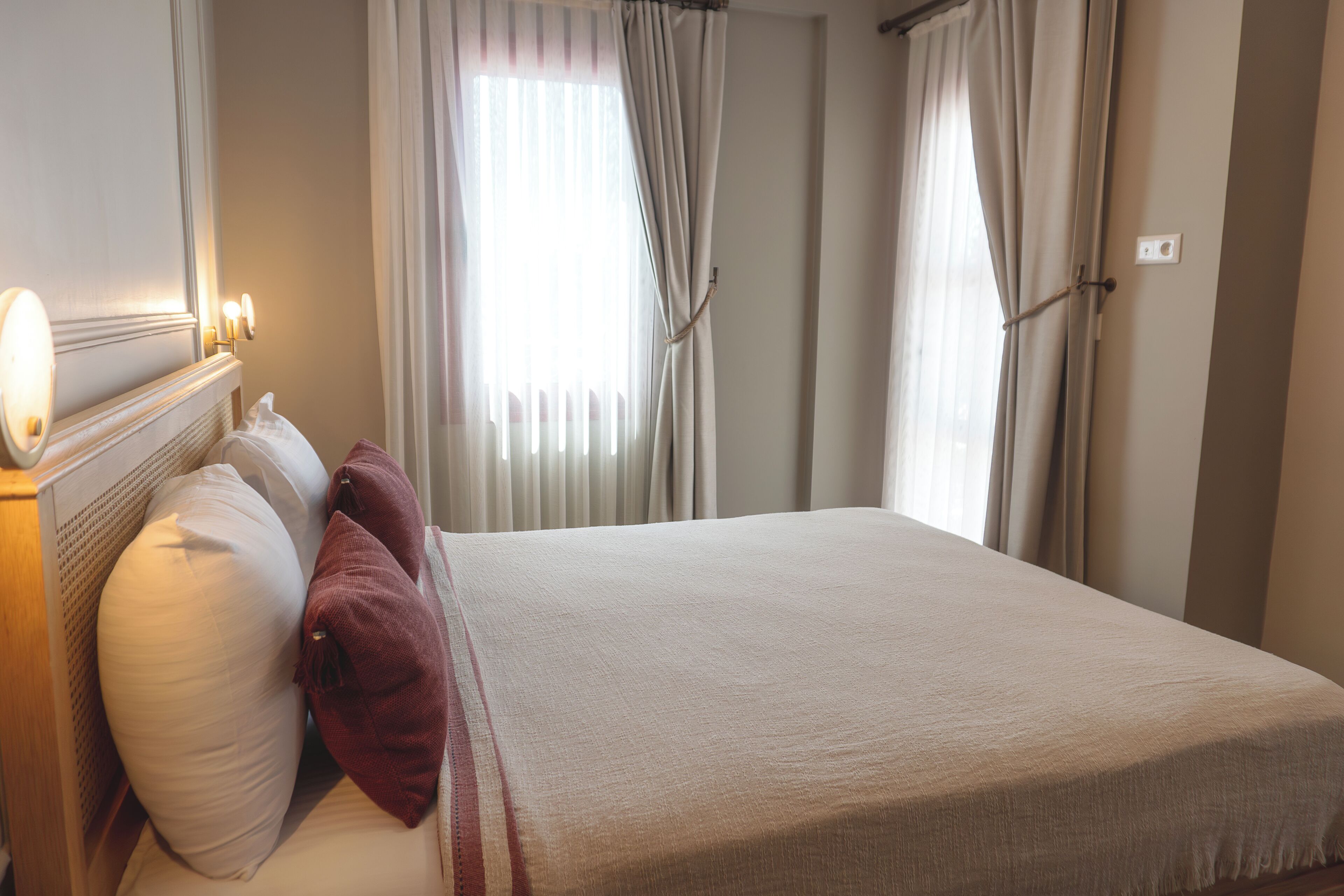 A neatly made bed with a headboard, two pillows, and a blanket.