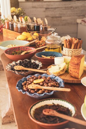 A buffet table with various food items and utensils. - Kapya Cunda (Ayvalik)