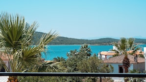 A coastal view with a clear sky, a turquoise sea, and a mountainous backdrop. - Kapya Cunda (Ayvalik)