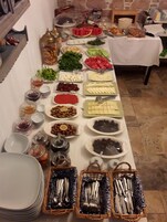 Uma mesa de buffet com diversos alimentos e utensílios.