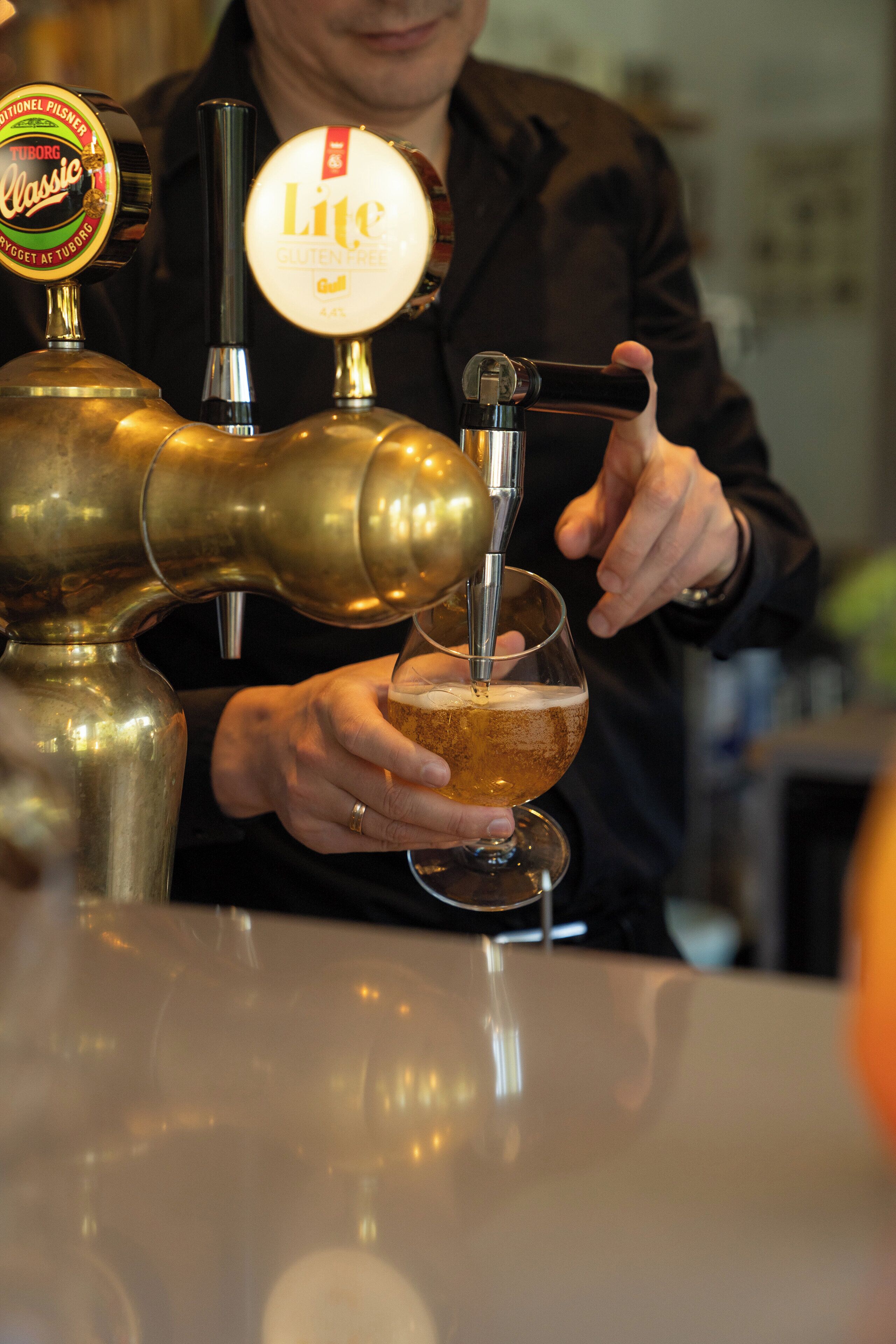 En bartender skænker øl fra fad i et glas.