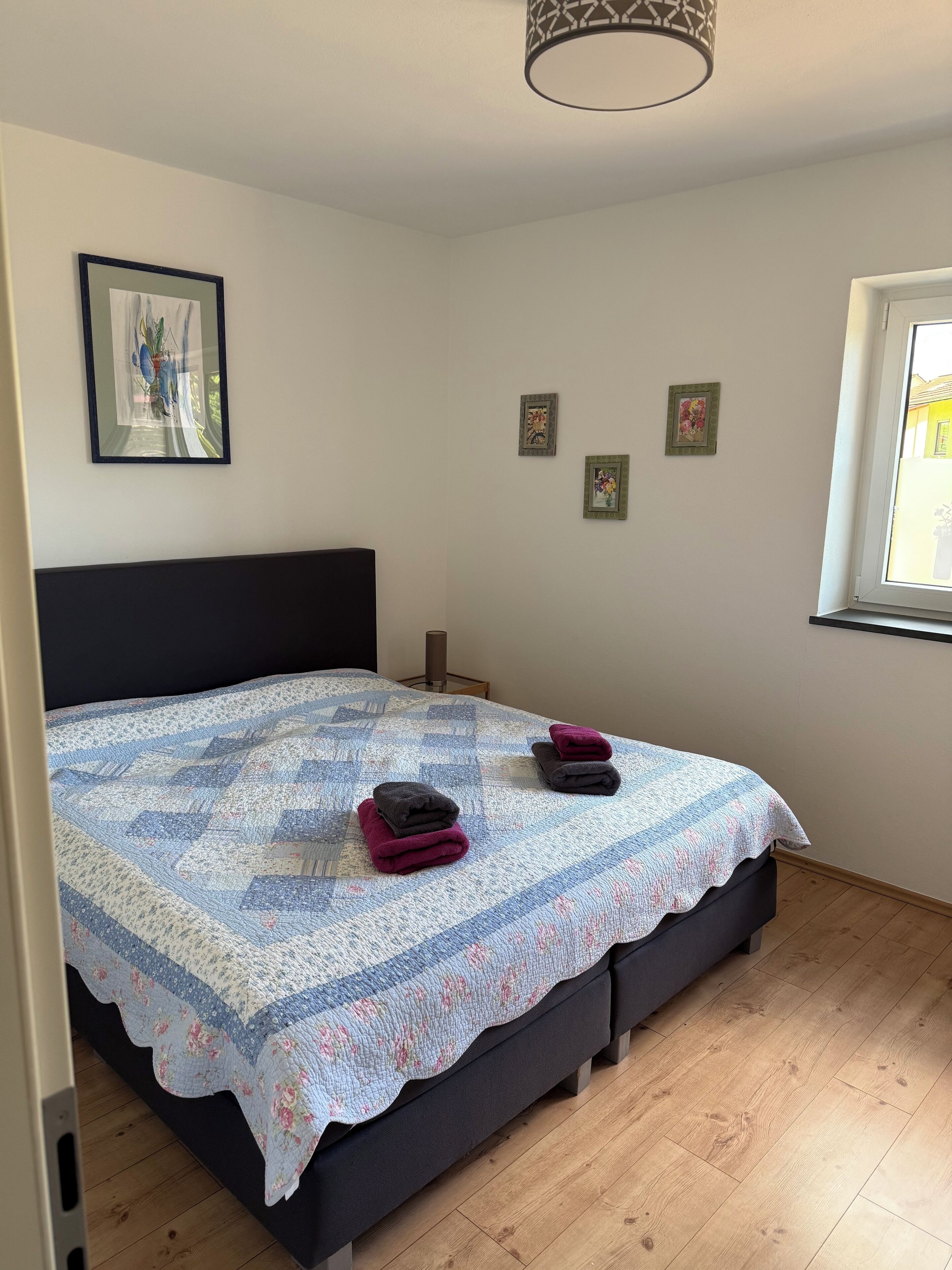 Ein Schlafzimmer mit Bett, Fenster und Tür.