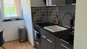Una cocina compacta con ventana, pileta y estufa.