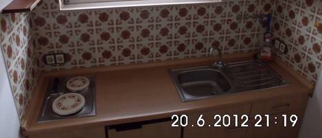 A small kitchen with a window, a sink, and a stove.